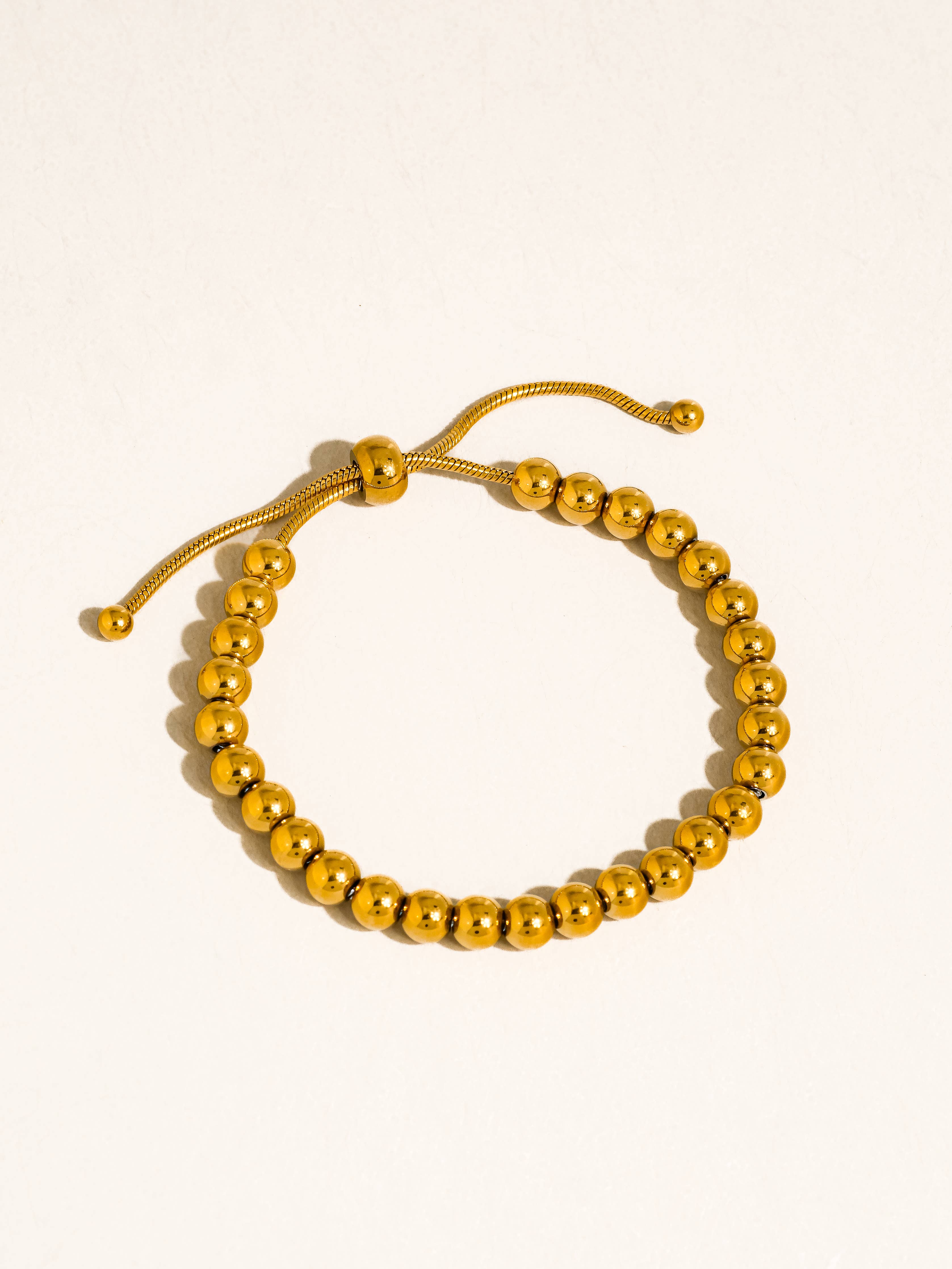 Liliane 18K gold beaded bracelet on white background, adjustable chain